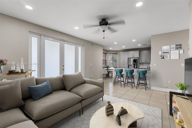 living area featuring baseboards, recessed lighting, ceiling fan, and light tile patterned floors