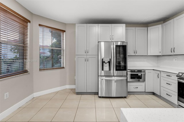 kitchen with light countertops, light tile patterned floors, baseboards, and stainless steel appliances