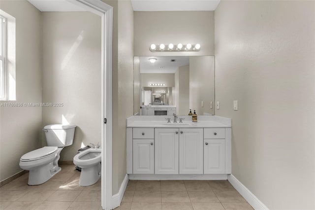 bathroom with vanity, a bidet, baseboards, tile patterned floors, and toilet