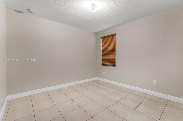 empty room featuring baseboards and a textured ceiling