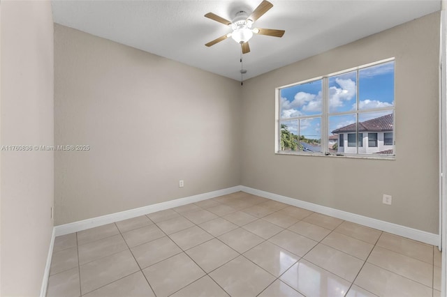empty room featuring light tile patterned floors, baseboards, and ceiling fan