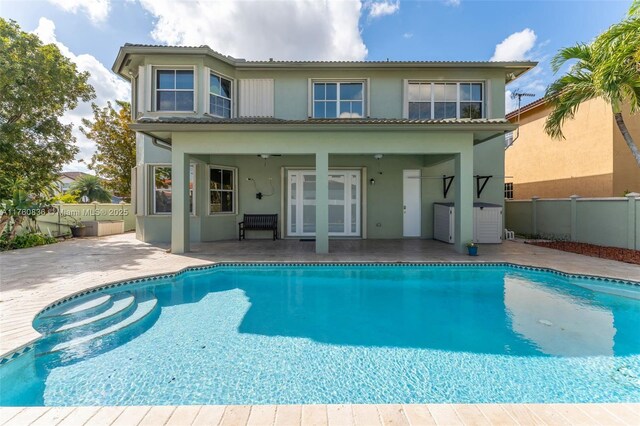 rear view of house featuring a patio, a tiled roof, and stucco siding