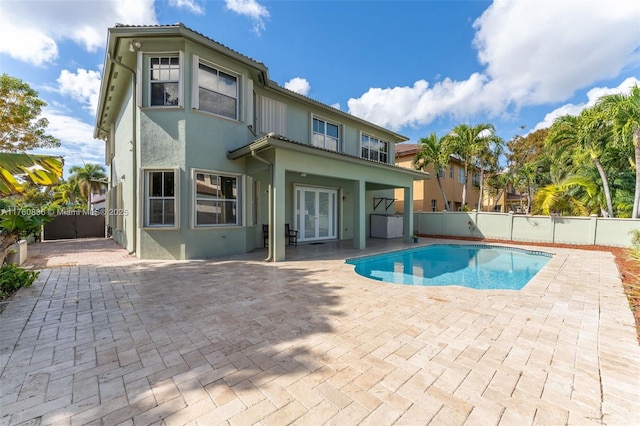 exterior space with french doors, a fenced in pool, a fenced backyard, a patio, and stucco siding