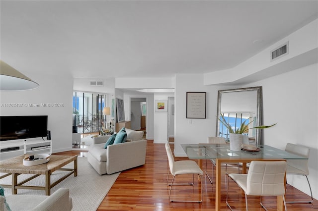 interior space with a wealth of natural light, visible vents, and wood finished floors