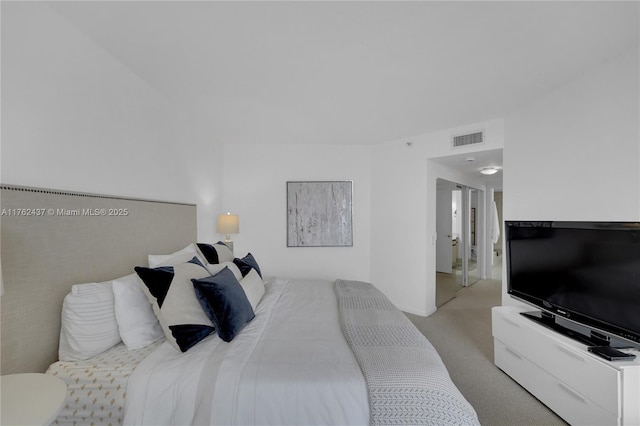 bedroom featuring visible vents and light colored carpet