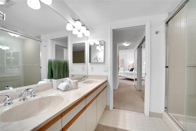 ensuite bathroom featuring tile patterned flooring, connected bathroom, a stall shower, and a sink