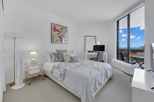 carpeted bedroom featuring a wall of windows