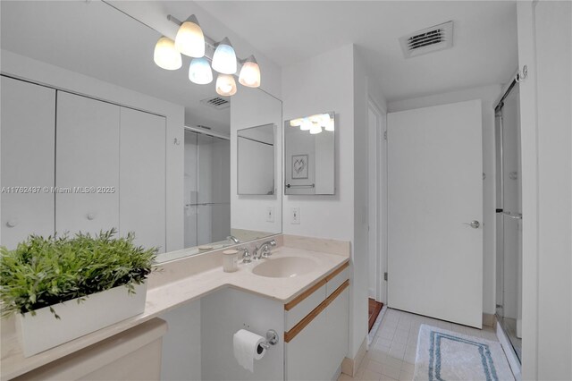 full bath featuring vanity, a shower stall, visible vents, and tile patterned flooring