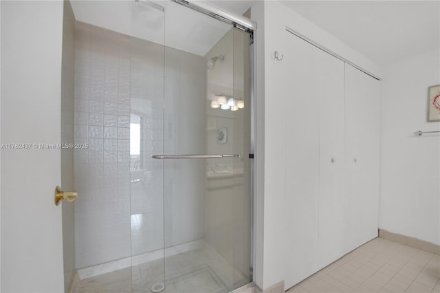 full bathroom featuring tile patterned floors and a shower stall