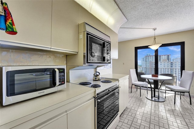 kitchen with stainless steel microwave, black microwave, white range with electric cooktop, light countertops, and a view of city