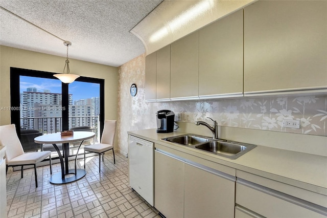 kitchen featuring a sink, hanging light fixtures, light countertops, dishwasher, and a view of city