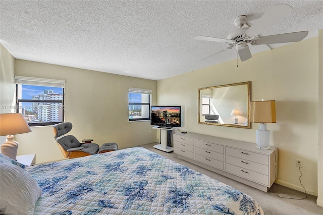 bedroom with light carpet, a textured ceiling, and a ceiling fan