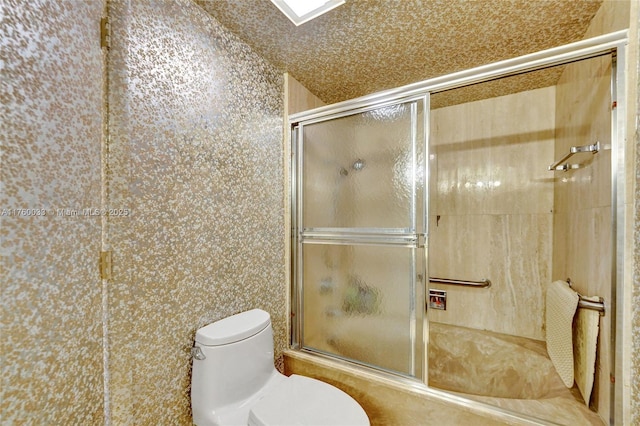 bathroom with toilet and a shower with door