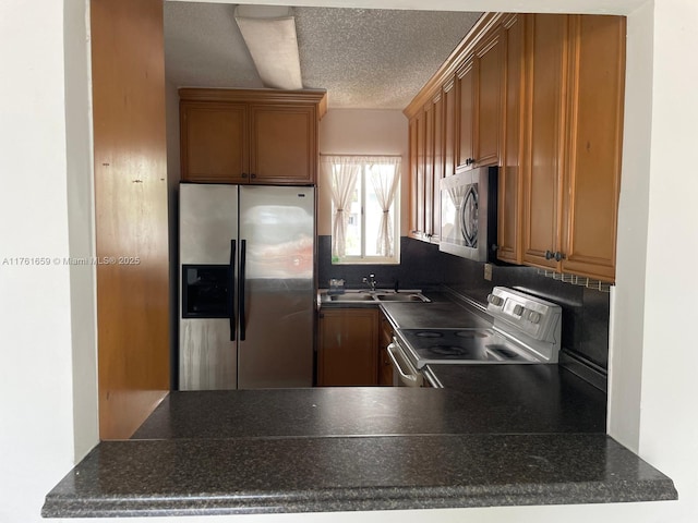 kitchen featuring a sink, dark countertops, and stainless steel appliances