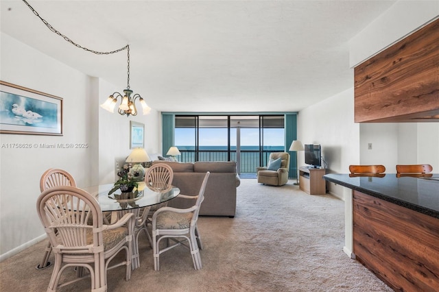 carpeted dining room featuring a wall of windows, an inviting chandelier, and baseboards