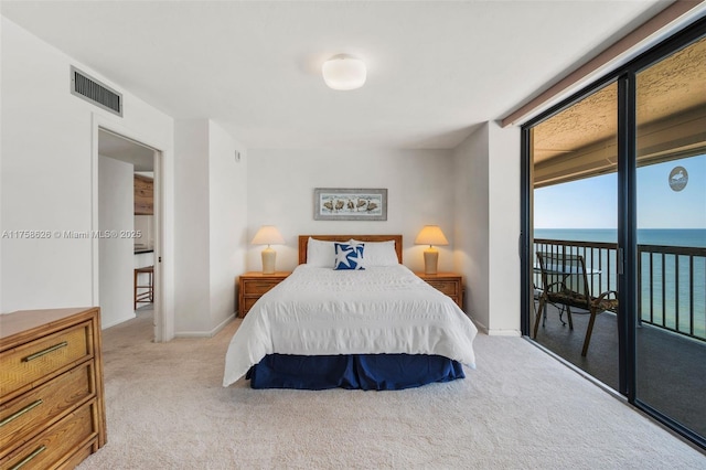 bedroom with a wall of windows, visible vents, a water view, light carpet, and access to outside