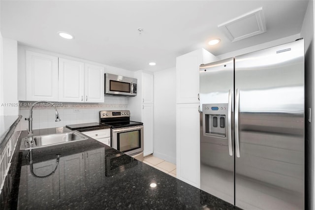 5601 Collins Ave Unit 1604, Miami Beach, FL 33140 - kitchen with a sink, white cabinetry, appliances with stainless steel finishes, light tile patterned floors, and decorative backsplash