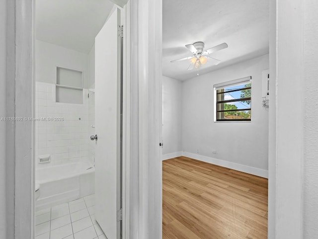 interior space featuring baseboards, light wood-style floors, and ceiling fan