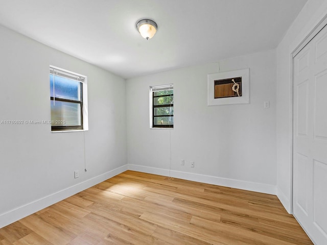 unfurnished room with baseboards and light wood finished floors