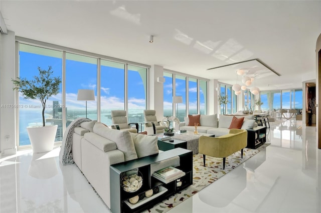 living room with a healthy amount of sunlight, a chandelier, and expansive windows