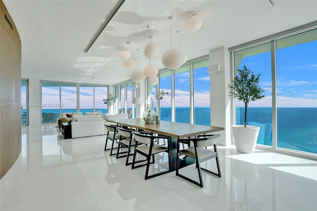 dining area with visible vents, a water view, and expansive windows