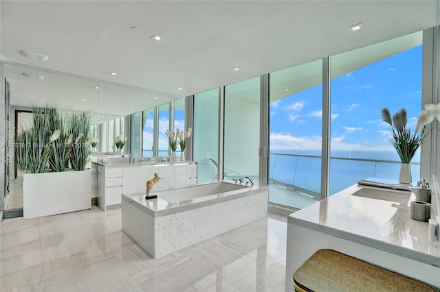 bathroom with vanity, a garden tub, and a water view