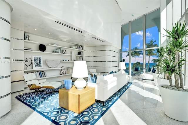 living room with a towering ceiling and floor to ceiling windows