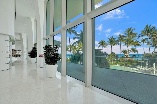 interior space with a high ceiling, a healthy amount of sunlight, and speckled floor