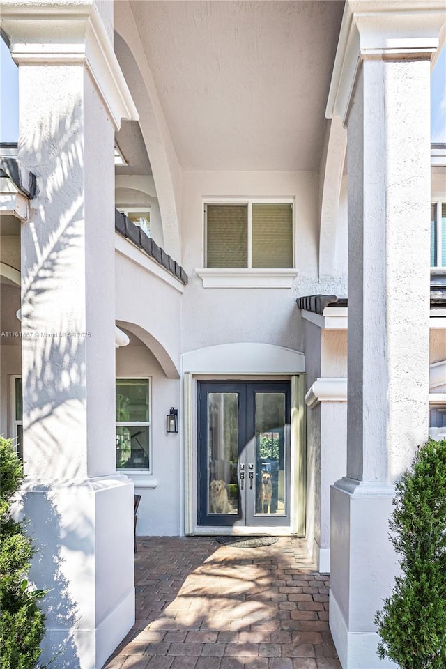 entrance to property featuring french doors and stucco siding