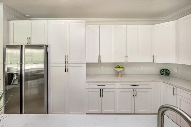 kitchen with white cabinets and stainless steel fridge with ice dispenser