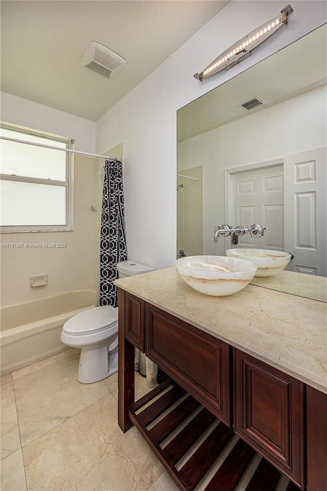 full bath featuring vanity, toilet, visible vents, and shower / tub combo with curtain