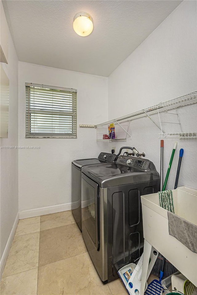 laundry area with laundry area, washer and dryer, baseboards, and a sink