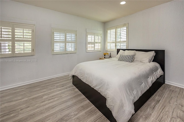 bedroom featuring recessed lighting, wood finished floors, and baseboards