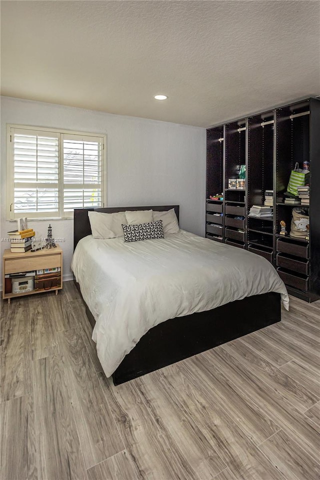 bedroom featuring a textured ceiling and wood finished floors