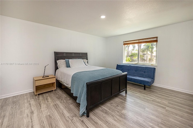 bedroom with recessed lighting, light wood-style floors, and baseboards