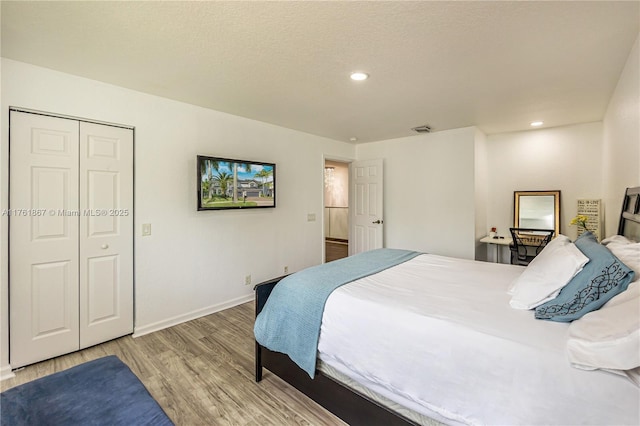 bedroom featuring visible vents, a textured ceiling, recessed lighting, light wood finished floors, and baseboards