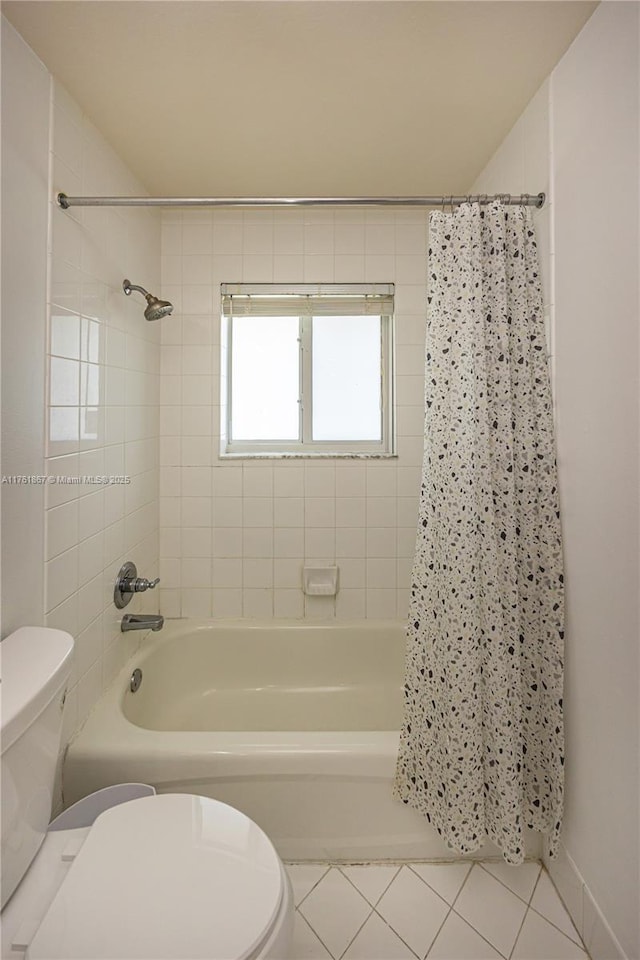 full bath with tile patterned floors, toilet, and shower / tub combo