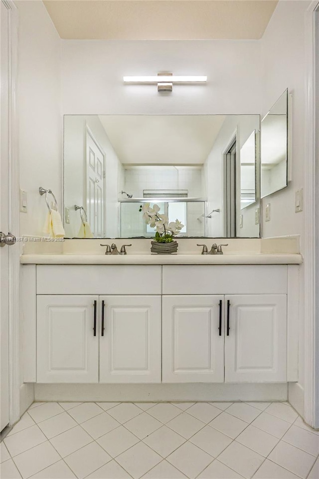 full bathroom featuring tile patterned flooring, a shower stall, double vanity, and a sink