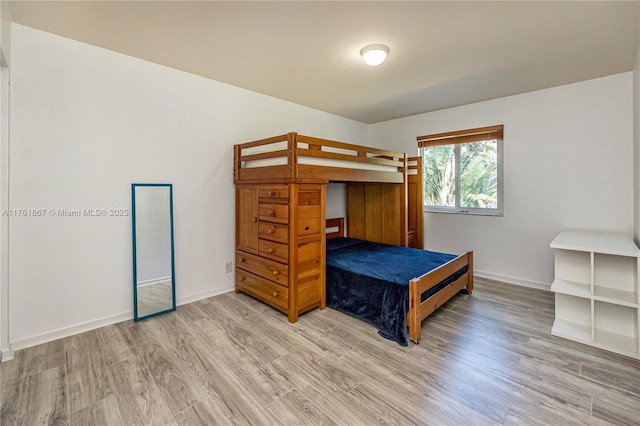 bedroom with light wood-style floors and baseboards