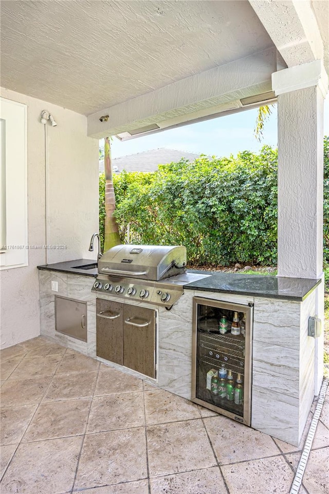 view of patio with a sink, wine cooler, area for grilling, and exterior kitchen