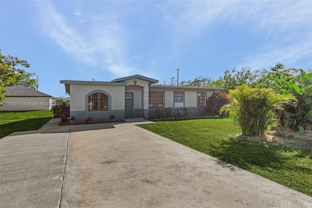 ranch-style home featuring stucco siding, driveway, and a front yard