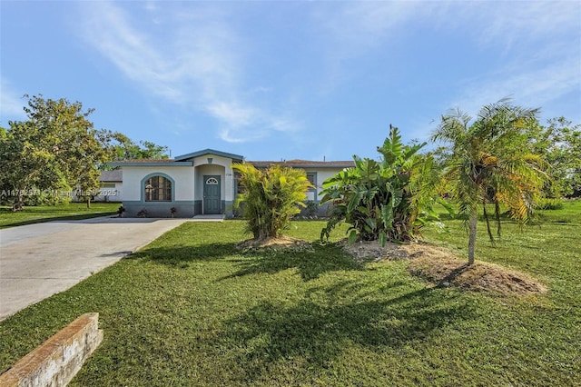 view of front of home featuring stucco siding, driveway, and a front yard