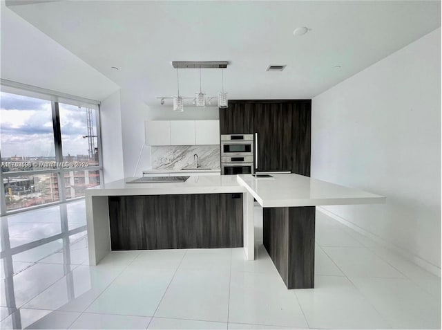 kitchen with visible vents, modern cabinets, a sink, light countertops, and black electric cooktop