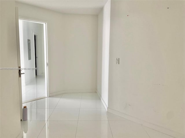 hallway with light tile patterned floors and baseboards