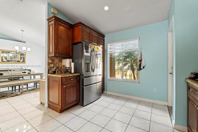 kitchen featuring light tile patterned floors, lofted ceiling, stainless steel fridge with ice dispenser, a textured ceiling, and a chandelier