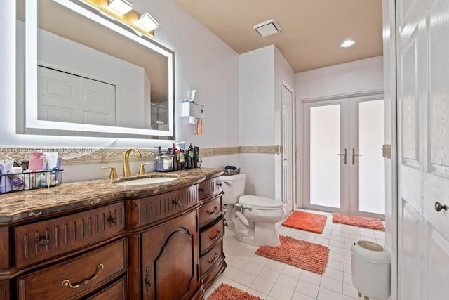 full bathroom with french doors, toilet, vanity, and tile patterned flooring