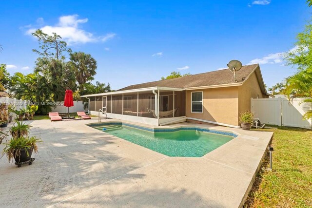 view of pool with a gate, a patio, a fenced backyard, a sunroom, and a fenced in pool