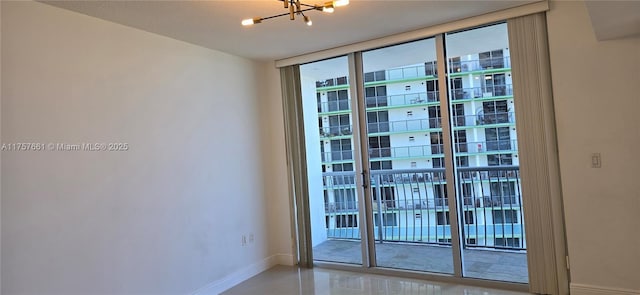 doorway with a chandelier, baseboards, and expansive windows