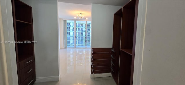 walk in closet featuring tile patterned floors and a notable chandelier