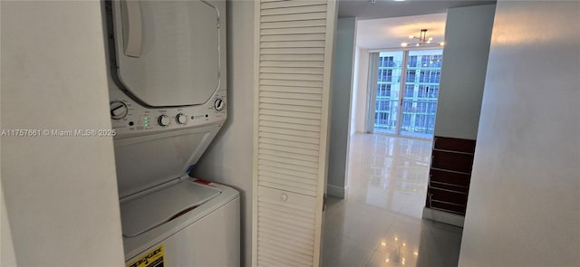 laundry area featuring tile patterned floors, stacked washer and dryer, and laundry area